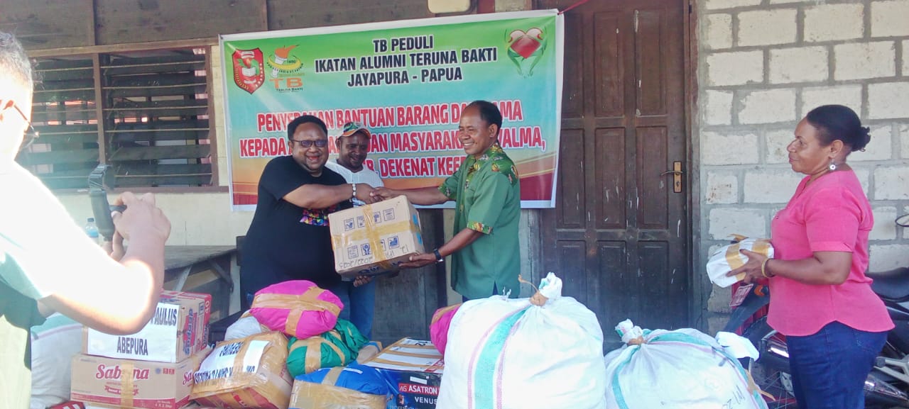 Ketua Alumni Teruna Bakti Jhon NR Gobai menyerahkan bantuan program Teruna Bakti Peduli bagi warga kampung Tevalma II